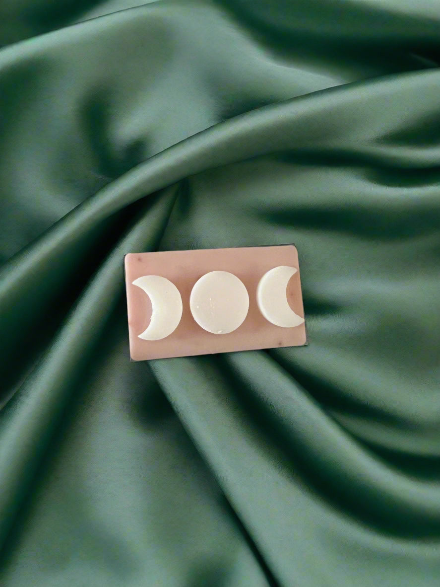 Rectangular product with moon phase design on a green textured fabric background