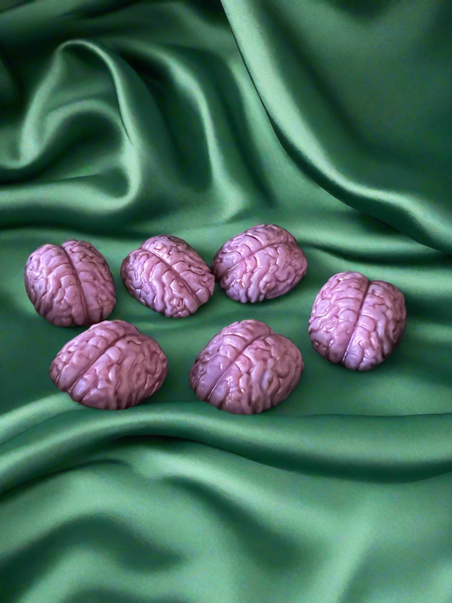 Six brain-shaped wax melts in purple colour, displayed on a dark background.