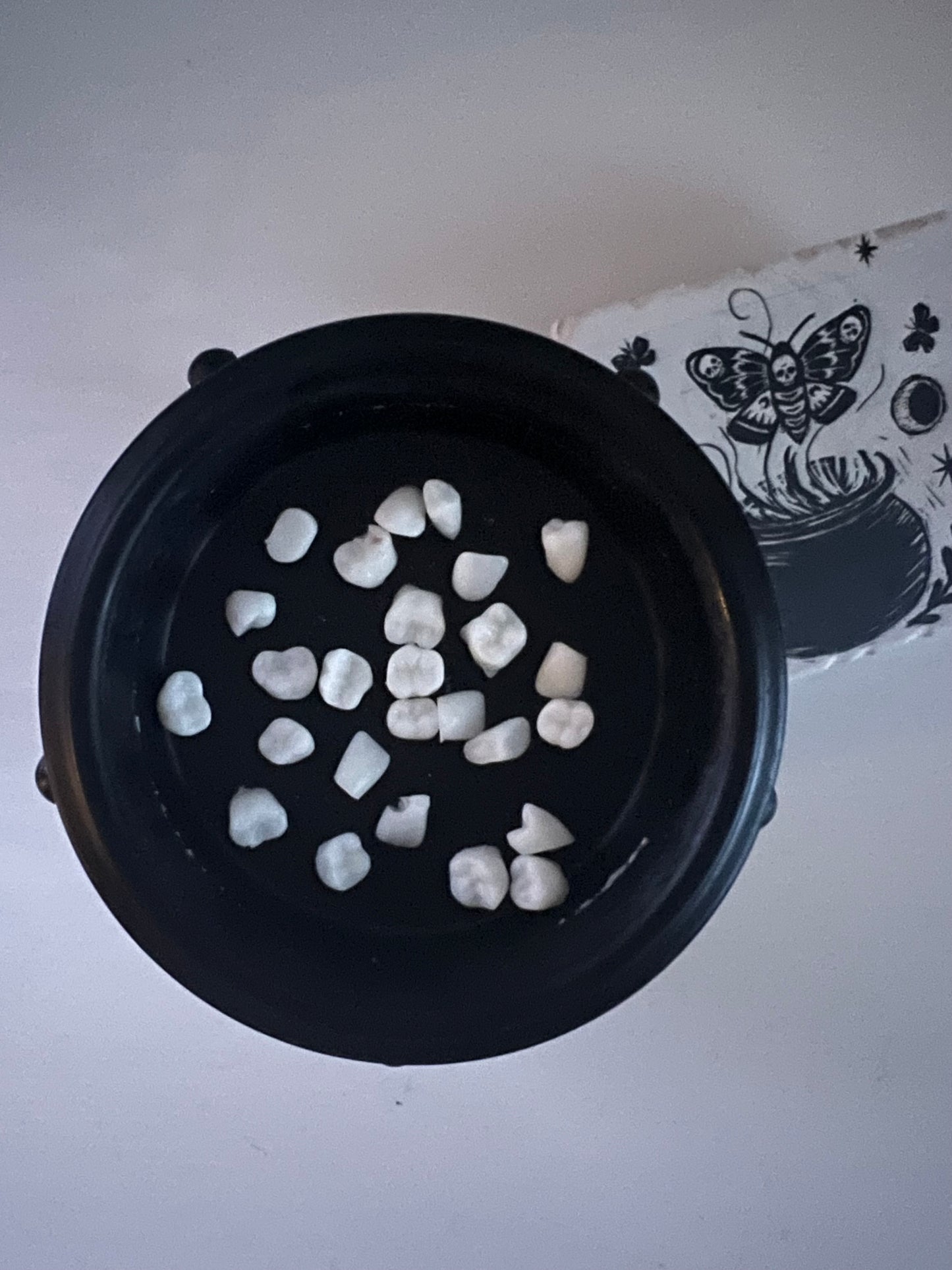 A collection of white wax melts shaped like teeth, placed on in a burner