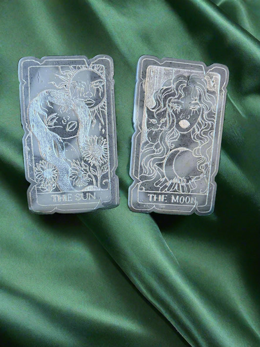 Two tarot card-shaped wax melts, one labeled 'THE SUN' and the other 'THE MOON', placed on a green fabric surface.