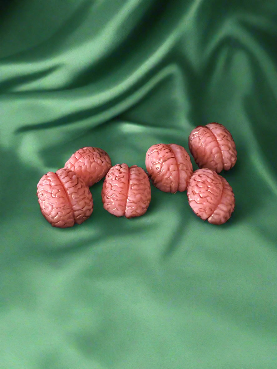 Six brain-shaped wax melts in pink color, displayed on a dark background.