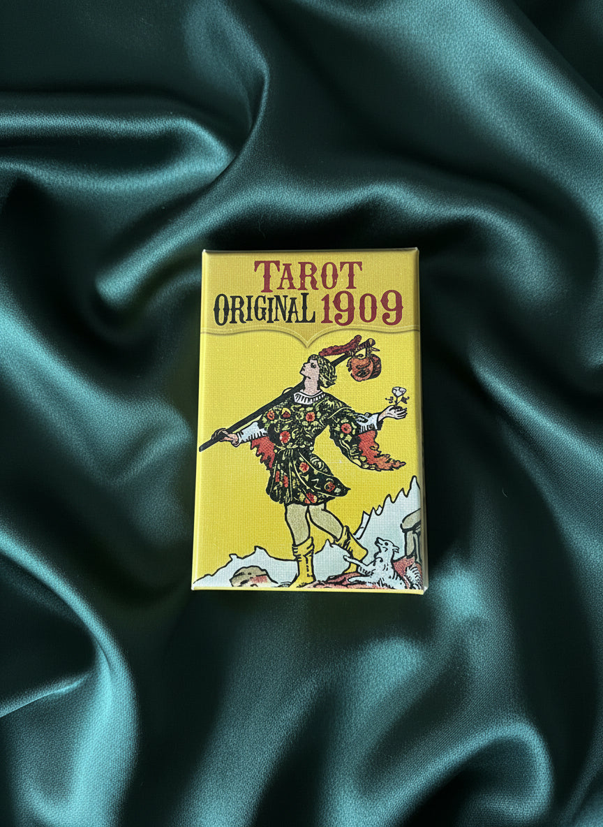 Yellow tarot card box with vintage design on a gray surface