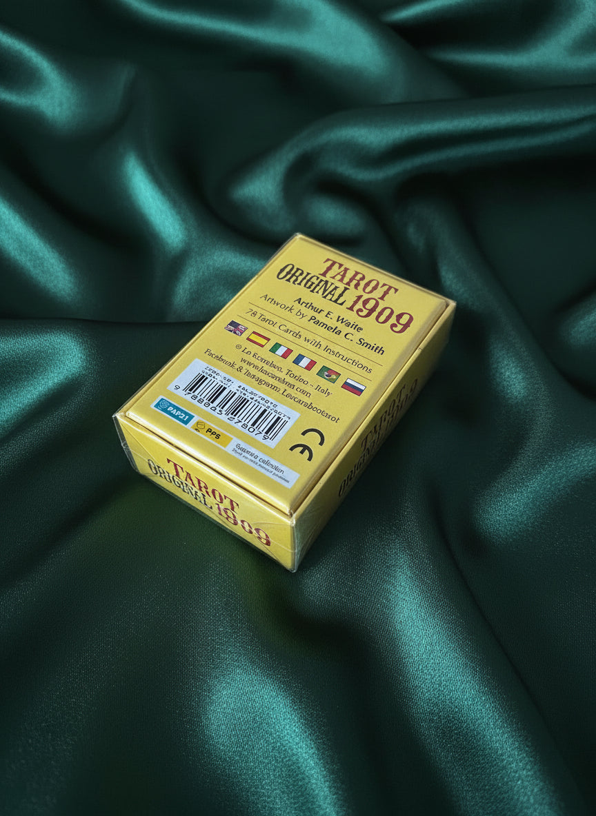 Gold tarot card box with text and barcodes on a wooden surface