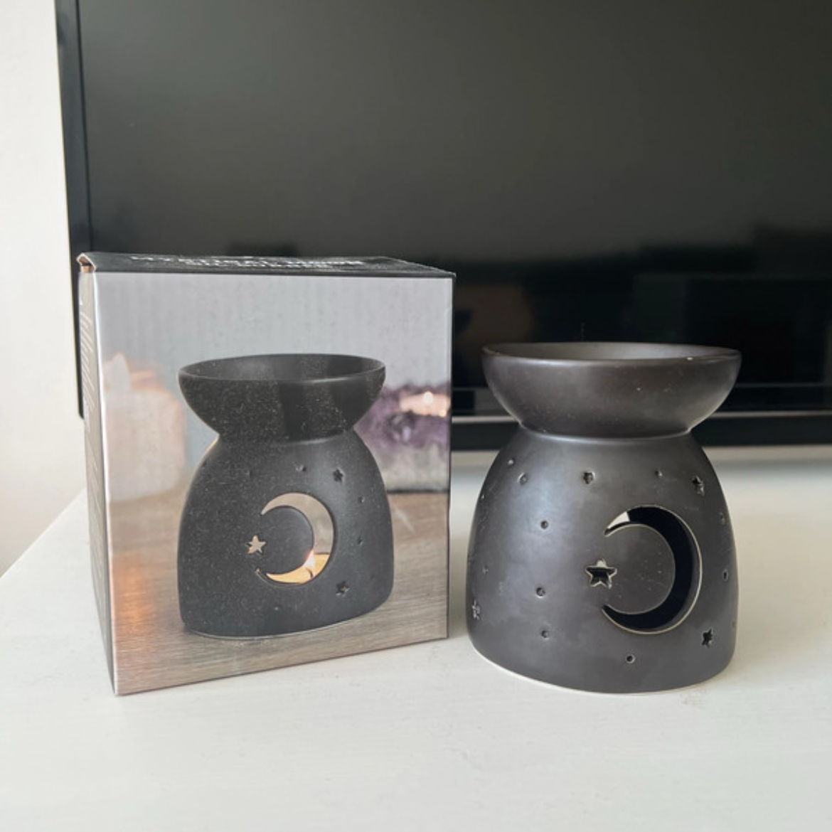 Black ceramic oil burners on a white surface, Moon and Stars