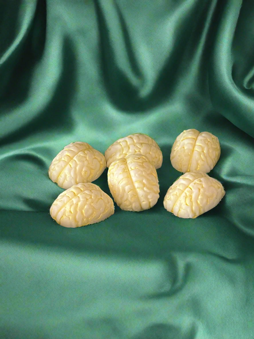 Six brain-shaped wax melts in white and gold, displayed on a dark background